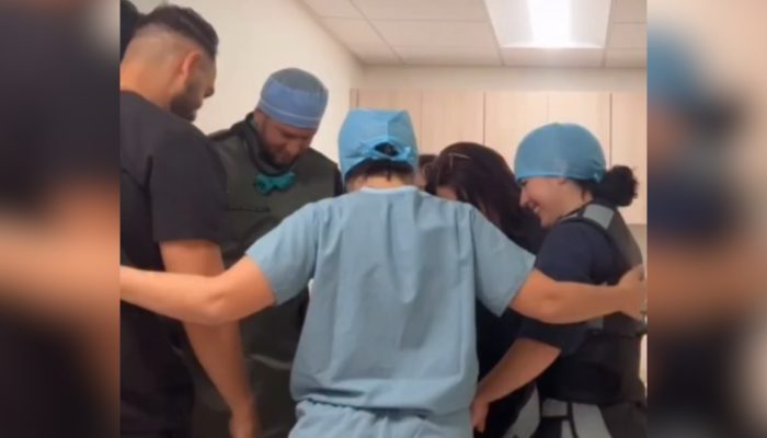 Equipe médica ora por pacientes antes das cirurgias: